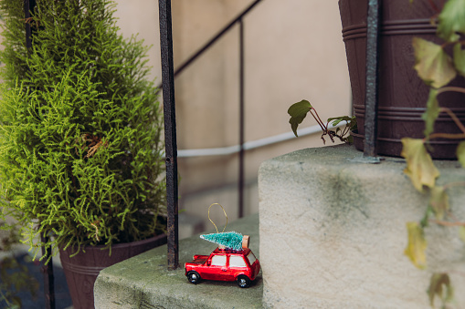 Small Christmas Tree toy - a red vintage car with green Christmas tree on the roof on the streets of old town of Krakow