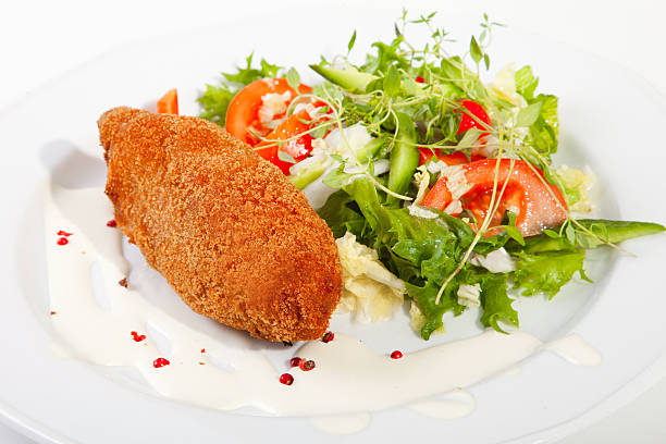 garlic chicken kiev with mixed leaf salad stock photo