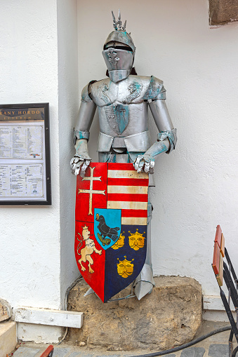 Budapest, Hungary - July 31, 2022: Knight Armour Protection Holding Medieval Style Heater Shield in Front of Restaurant at Castle District.