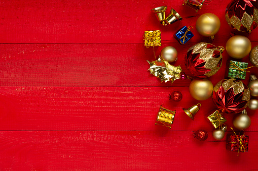 Christmas composition with festive red craft boxes and red ribbons and small balls on red background. Flat lay, top view, copy space. Minimal New Year concept.