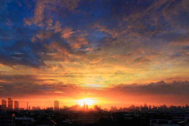 Background of orange sky with clouds and sunset in city.