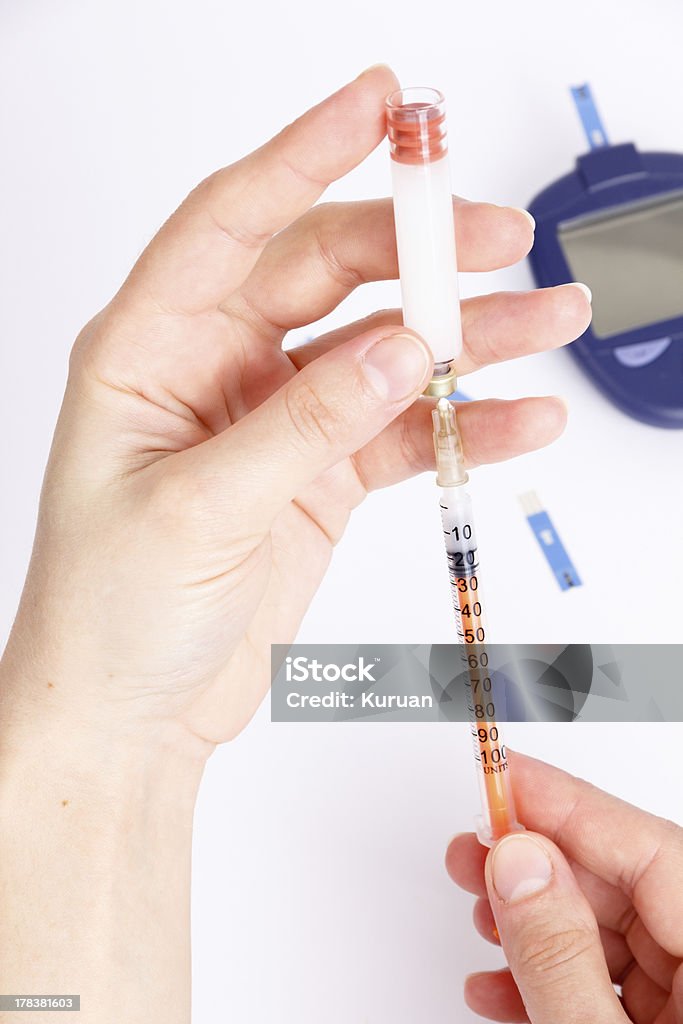 Female hands type in a syringe insulin with Glucose Meter Analyzing Stock Photo