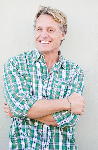 happy smiling mature man color portrait photo of a happy man in his late forties with blond hair looking to the side with his arms folded. 40 49 years stock pictures, royalty-free photos & images