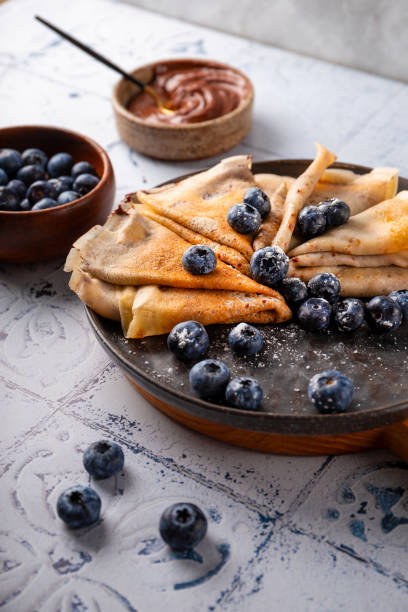 istock Thin pancakes with chocolate spread and blueberries on the table vertical photo 1783819059