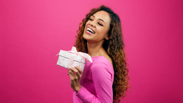 istock Beautiful young woman poses with gift box pink studio, Valentines or anniversary 1783829018