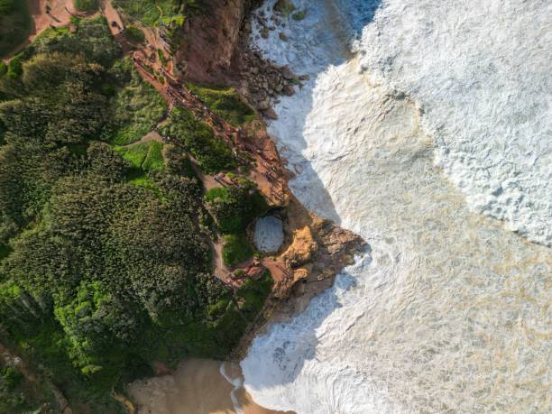 istock a long sandy beach with small waves coming up from the cliff 1783837734