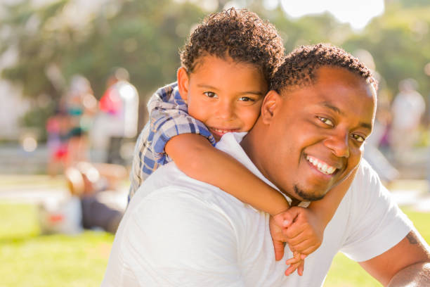 istock Father and son playing piggyback in park 178383993