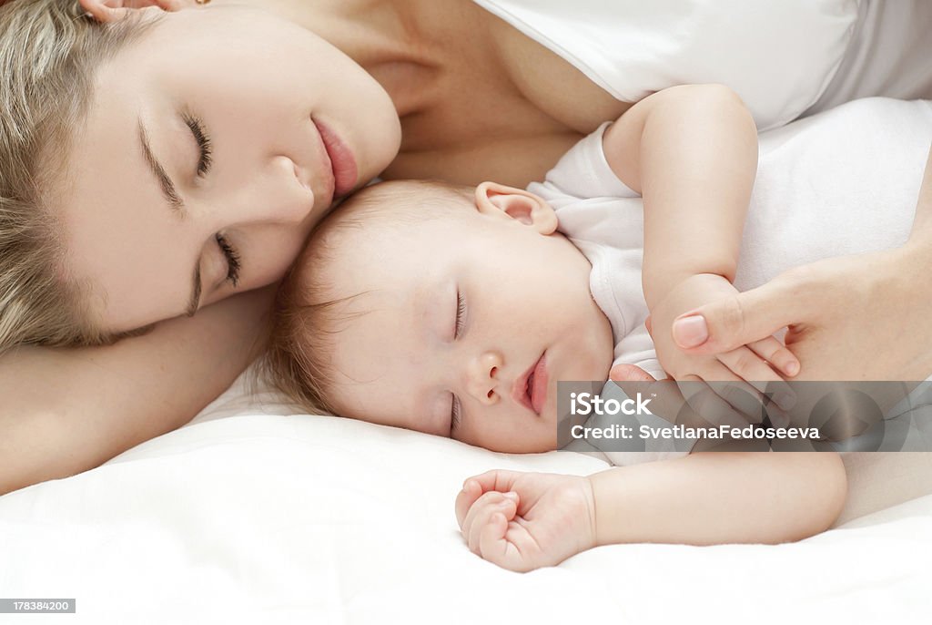 mother's tenderness "Young mother and her baby, sleeping in bed" Mother Stock Photo