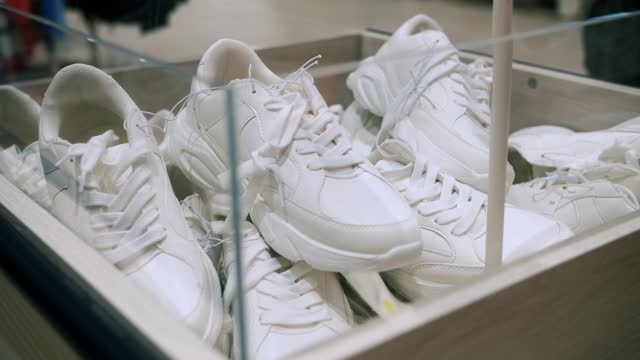 shoe sale. new white sneakers in the store. casual flat footwear. close-up. box with white sneakers. sale in a shoe store or shoe department of a shopping mall or supermarket.