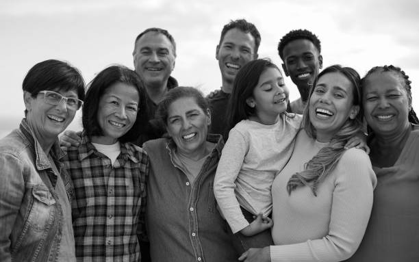 istock Group of multi generational people hugging each other outdoor while smiling in front of camera - Multiracial friends having fun together at house rooftop - Black and white editing 1783844510