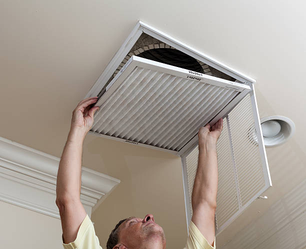Senior man opening air conditioning filter in ceiling stock photo