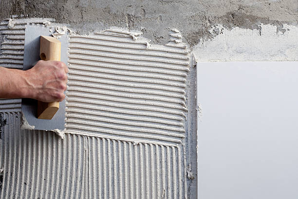construction notched trowel with white cement construction notched trowel with white cement mortar for tiles work rough hands man stock pictures, royalty-free photos & images