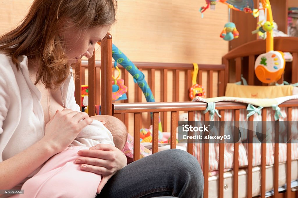 Mother to breastfeed her baby Loving mother to breastfeed her little newborn daughter Adult Stock Photo