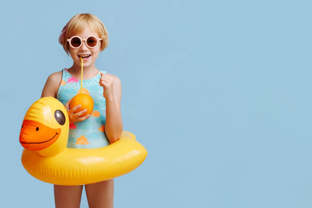 istock Child with inflatable duck ring on blue background with copy space. 1783857659