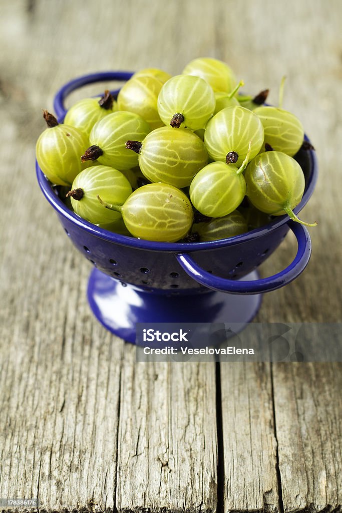 Fresh gooseberries in blue colander Backgrounds Stock Photo