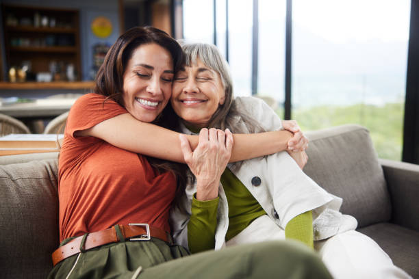 istock Smiling woman hugging her mom on a sofa during a visit 1783866896