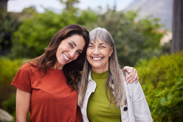 istock Woman and her senior mom smiling while standing together outside 1783873499