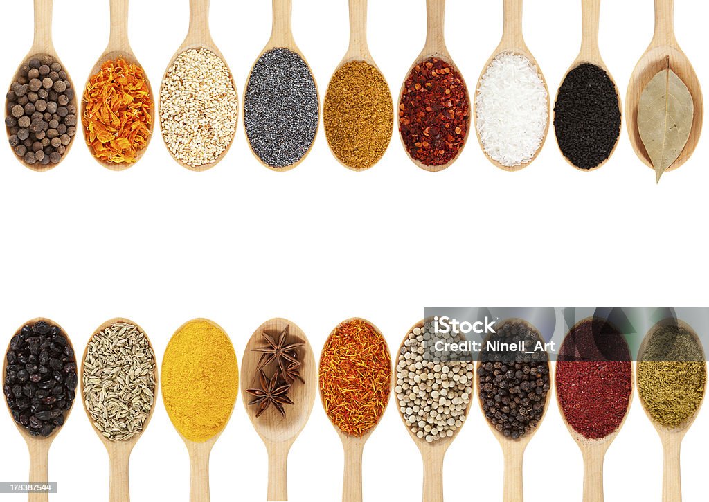 spices Collection of 18 spices on a wooden spoon. isolated on a white background Spoon Stock Photo