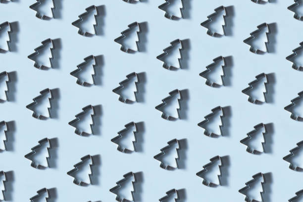 Christmas Tree Shaped Cookie Cutters in a Row on Blue Background