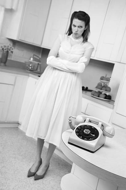 Unhappy cute young woman waiting by telephone