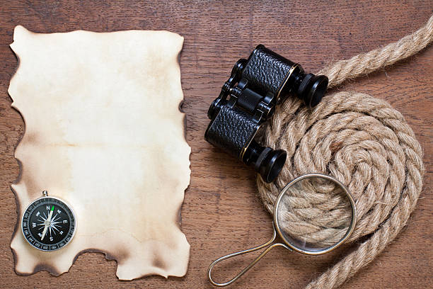 istock Compass, burnt paper, magnifying glass, rope, binoculars on wood 178388633