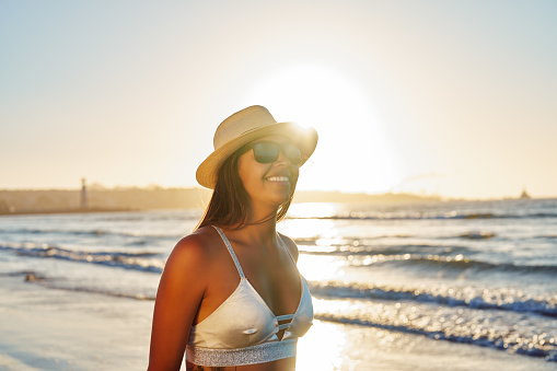 headshot portrait young latin american woman on the beach happy at sunset
