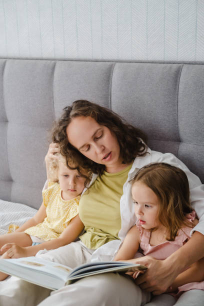 istock Mother reading a book her daughters at home 1783889464
