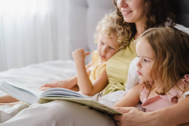 istock Mother reading a book her daughters at home 1783890009