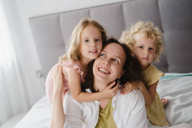 istock Mother hugging with two little daughters in bed 1783892835