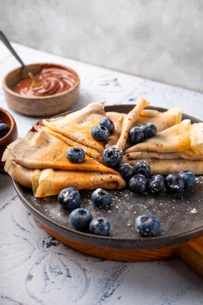 istock Thin pancakes with chocolate spread and blueberries on the table vertical photo 1783893959
