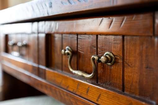 Iron vintage handle on brown antique drawer, interior of the house room, close-up