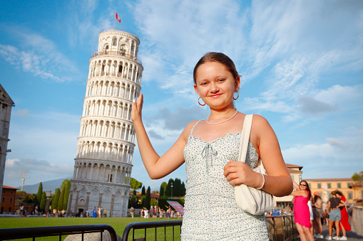 Young girl posing with the Leaning Tower in Pisa