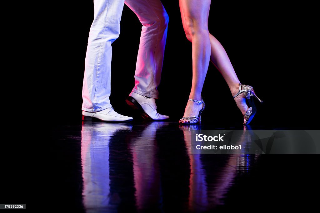 Couple of dancers during a routine on the dance floor A couple of professional latin dancers.Close up of dancer`s feet with dramatic light. Dancing Stock Photo