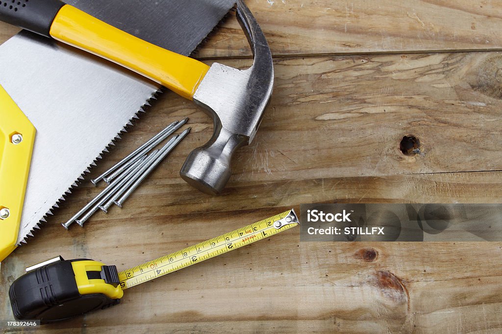 Tools "Hammer, saw, nails and tape measure on wood" Work Tool Stock Photo
