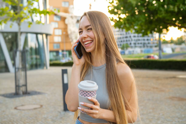 istock Young woman drinks hot coffee having conversation on phone 1783929762