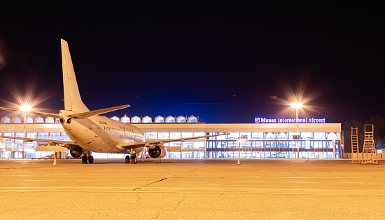 Bishkek, Kyrgyzstan - September 26, 2023: Manas International Airport building with airplane at night