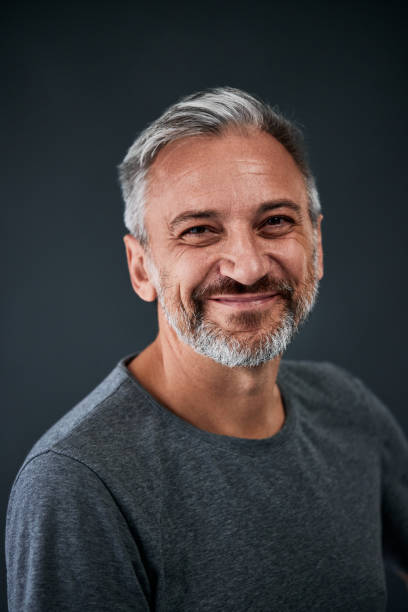 istock A happy man isolated in the grey background, dressed in a grey sweater. 1783930940