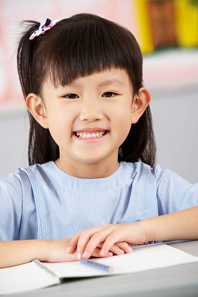 istock Female Student Working At Desk In Chinese School Classroom 178393262