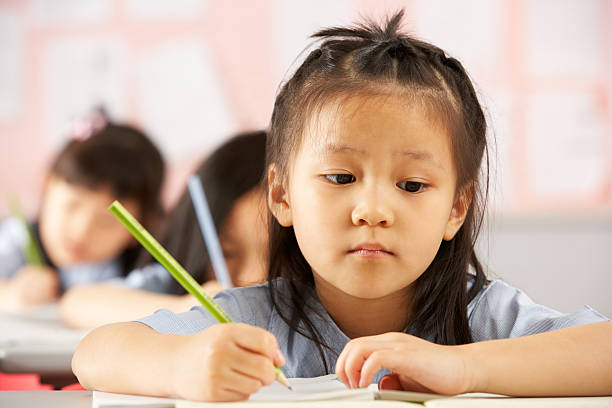 istock Group Of Students Working At Desks In Chinese School Classroom 178393620