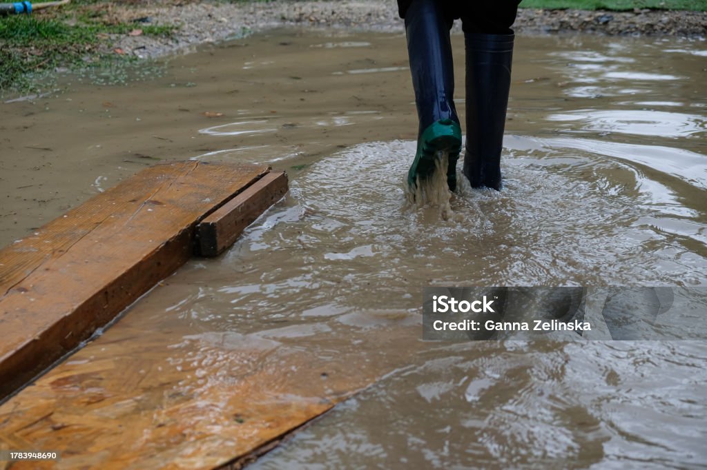 A puddle after heavy rain. A child in rubber boots. A puddle after heavy rain. A child in rubber boots, out of size, walks in water. Flood Stock Photo A puddle after heavy rain. A child in rubber boots. A puddle after heavy rain. A child in rubber boots, out of size, walks in water. Flood Stock Photo