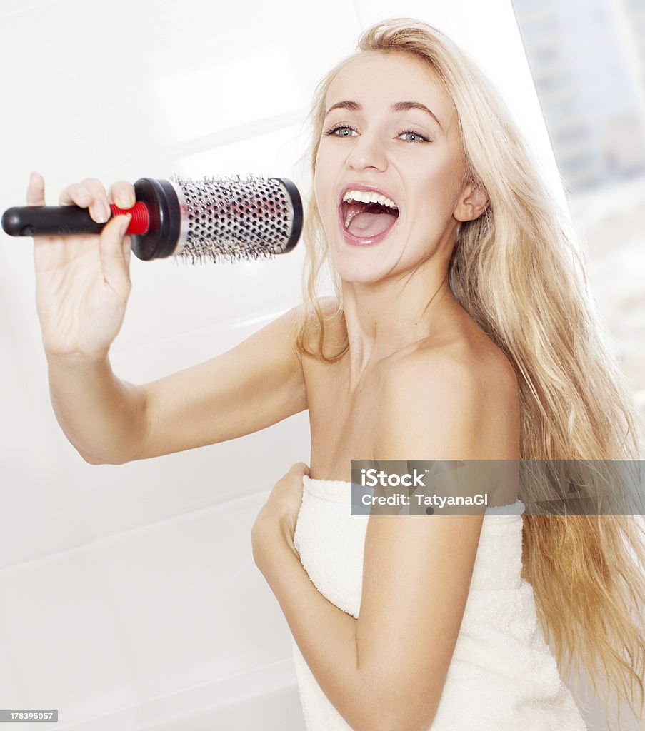 Young woman in the morning at bathroom Woman in the morning at bathroom. Funny female sing song in comb Singing Stock Photo