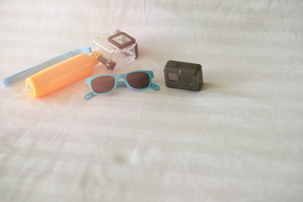istock travel gears ,action camera ,handle stick,sunglasses on bed ,top view 1783952744