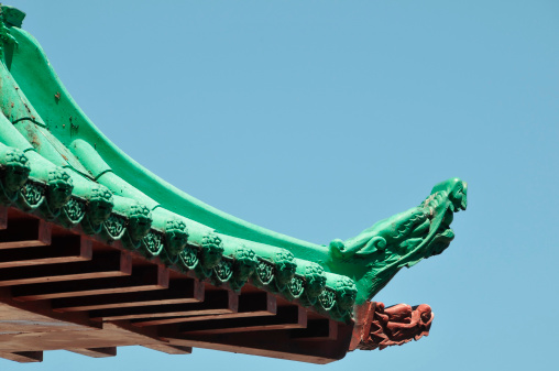 A wooden chinese roof dragon colored in green