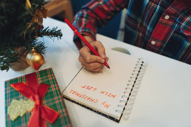 istock unrecognizable boy writing christmas wish list sitting at the table at home 1783957253