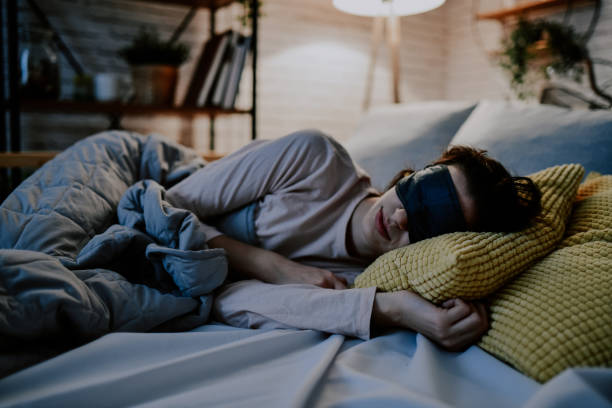 Eye Mask Protecting Female With Sensitive Sleep Pattern From Excess Light Eye Mask Protecting Female With Sensitive Sleep Pattern From Excess Light sleep eye mask stock pictures, royalty-free photos & images