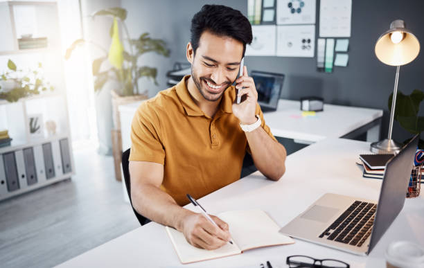 istock Happy man, phone call and writing notes for business planning, online project or creative development. Asian person or graphic designer talking in office communication,  notebook planner and computer 1783968646