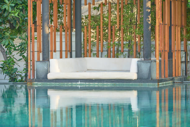 istock sofa beside swimming pool on wooden decorate background 1783972780
