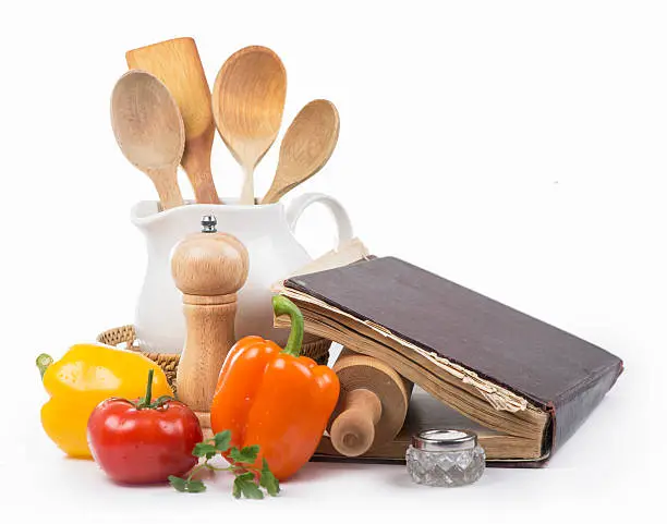 recipe-book, rolling pin, wooden spoons, salt, vegetables on a white background