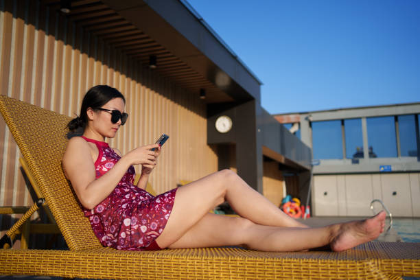 istock woman sunbathing on deck chair 1783979231