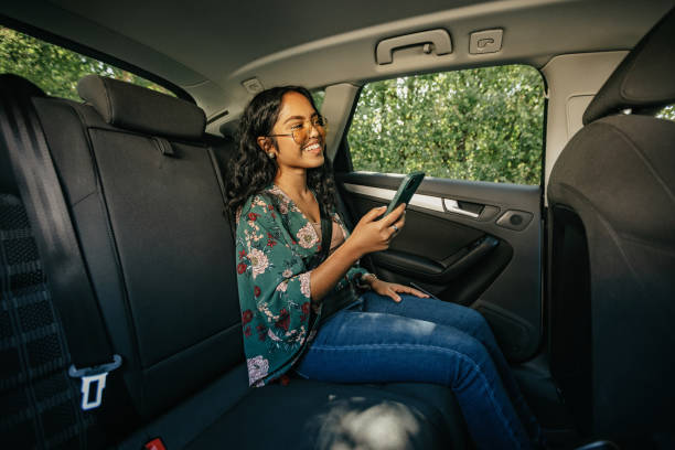 istock Young woman using phone on back seat of a car 1783979239